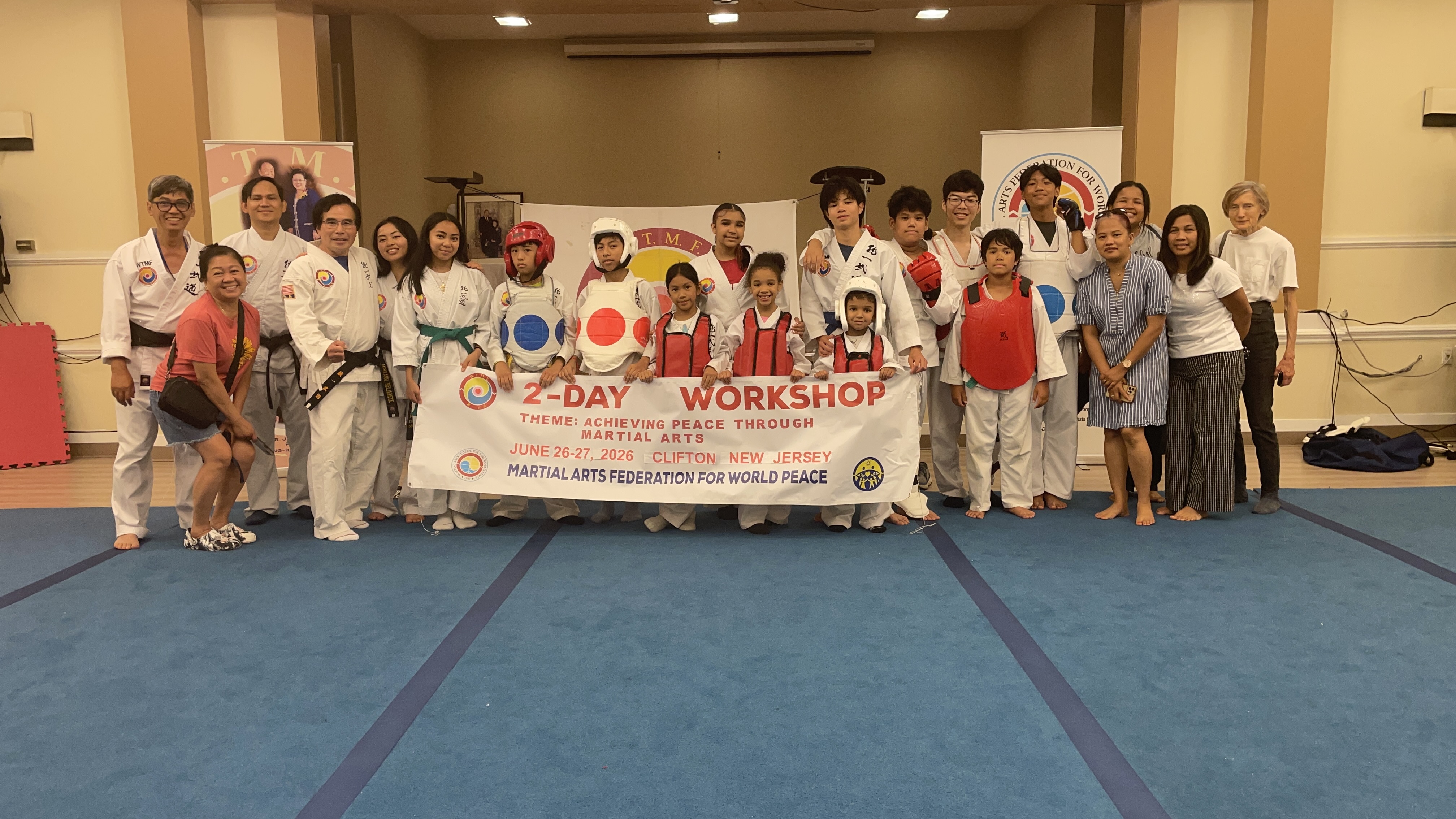 Participants, instructors, and families holding the 2-Day Workshop banner at Clifton Family Church