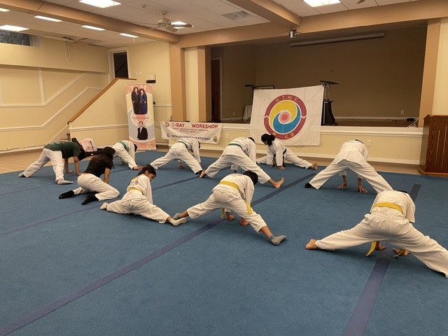 Warm-Up & Stretching — Partner stretching to open the morning session.